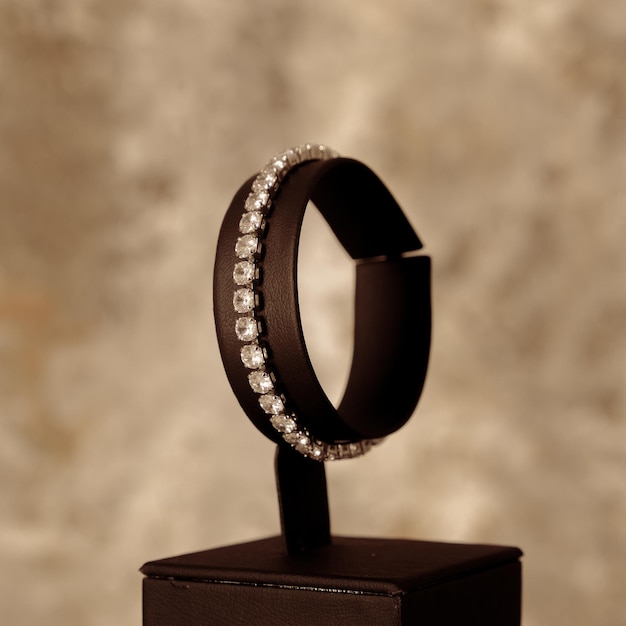 Une bague noire avec des diamants est sur une boîte noire.