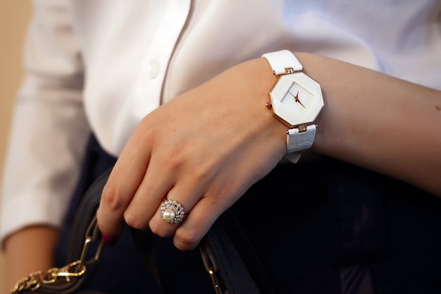 Une bague avec des pierres et une montre sur la main d'une fille
