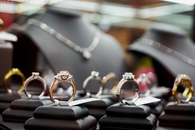 Les bagues et colliers en diamant de bijoux sont exposés dans une vitrine de vitrine de magasin de détail de luxe