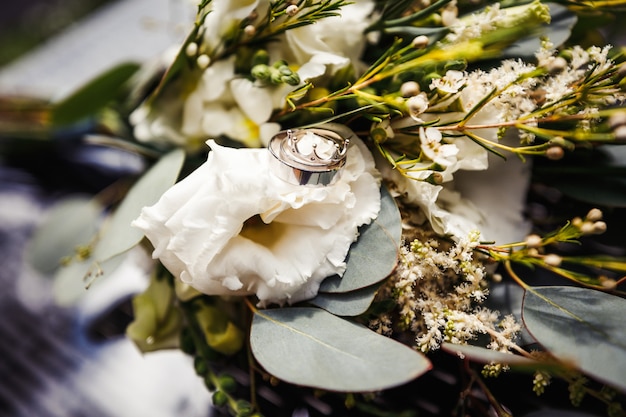 Bagues de mariage dorées élégantes sur les fleurs