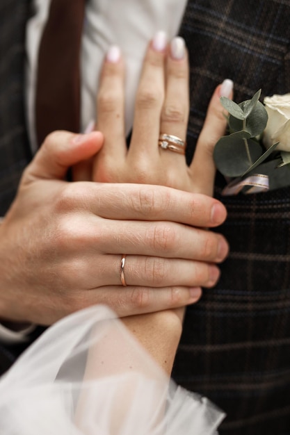 des bagues de mariage sur les mains des jeunes mariés au mariage