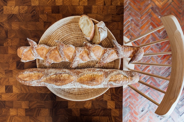 Baguette Au Four Fraîchement Et Chaud Dans Le Panier Sur La Table En Bois. Fabriqué Par Artisan.