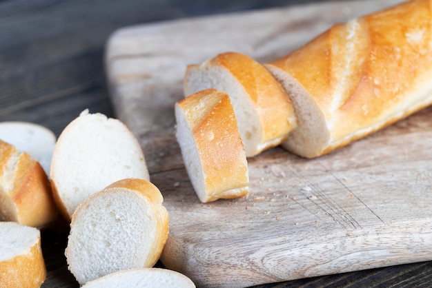 Baguette de blé coupée en morceaux sur une planche à découper