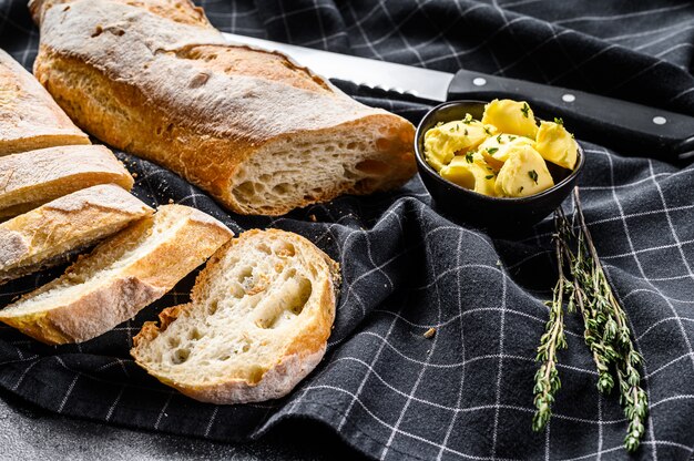 Baguette française au beurre pour le petit déjeuner. fond noir. vue de dessus