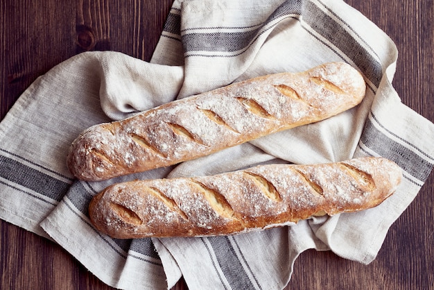 Baguette française croustillante maison fraîchement cuite. Deux pains sur une serviette en lin