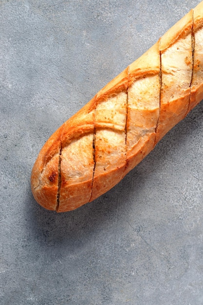 Photo baguette de pain à l'ail en tranches grillées sur fond de pierre grise boulangerie conceptxa