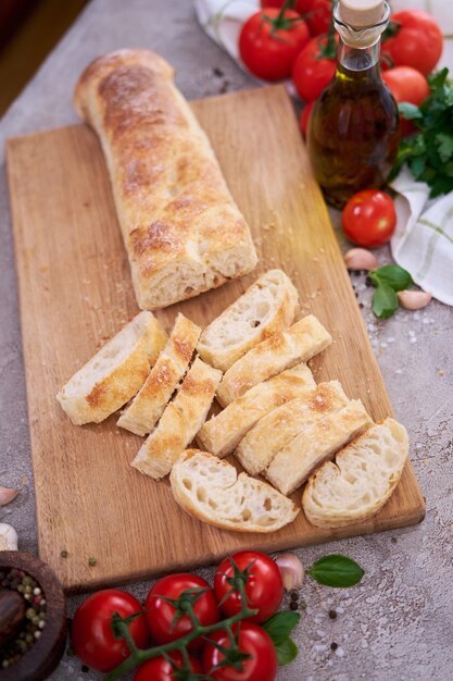 Baguette de pain français en tranches sur planche à pain en bois