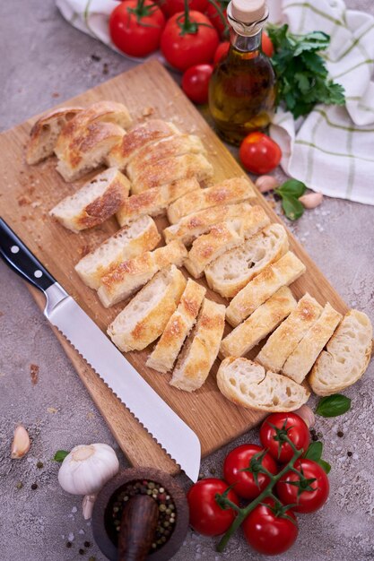 Baguette de pain français en tranches sur planche à pain en bois