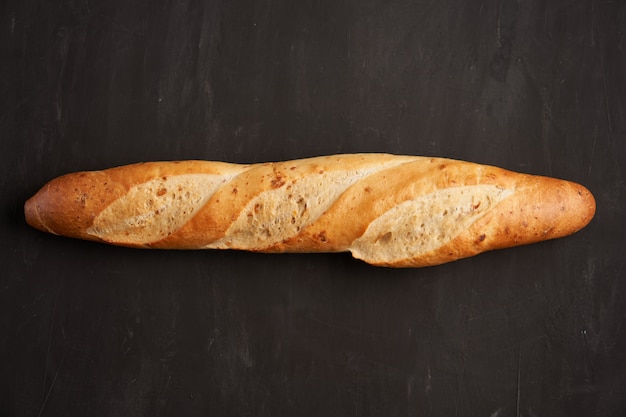 Une baguettes françaises croustillantes se trouvent sur fond de tableau noir foncé