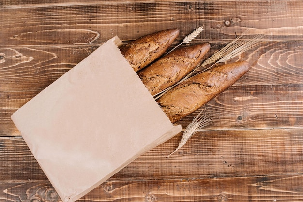 Baguettes françaises fraîches dans un sac en papier sur le fond en bois. vue de dessus