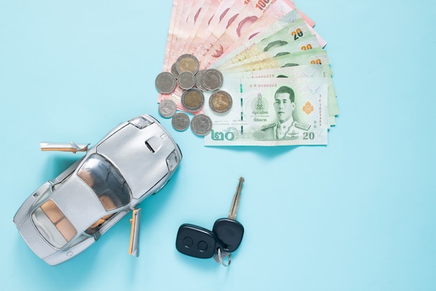 Baht thaïlandais, billets de banque et pièces de monnaie avec modèle de voiture sur fond de couleur