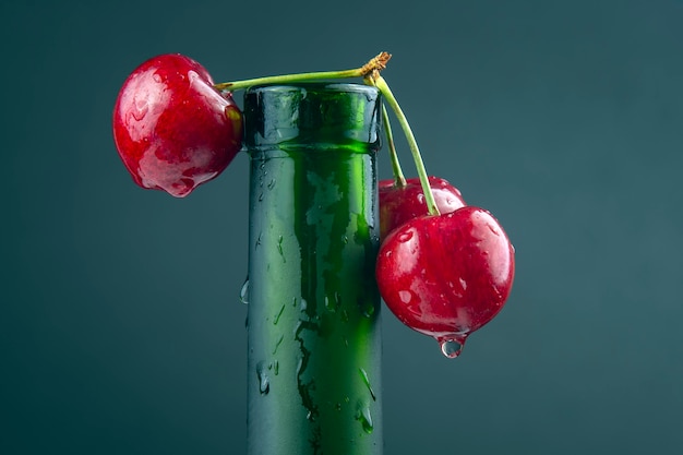 Baie de cerise fraîche avec des gouttelettes d'eau sur une bouteille verte. nourriture saine pour le petit déjeuner. fruits de la végétation. dessert aux fruits