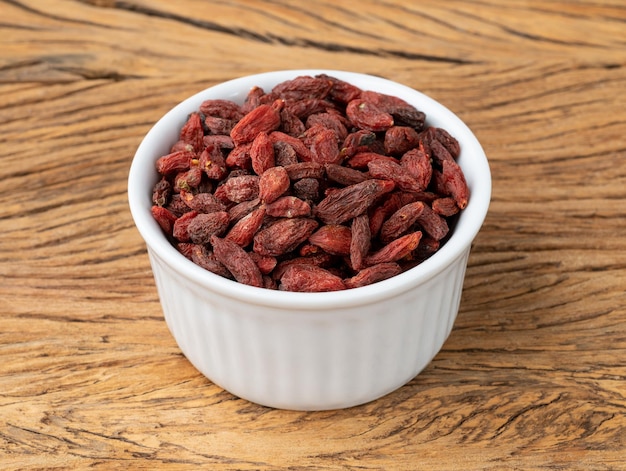 Baie de Goji dans un bol sur une table en bois