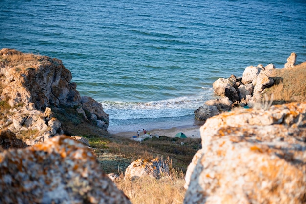 Baie de mer montagneuse avec un rivage sablonneux et un camp touristique avec des voyages et du tourisme touristiques