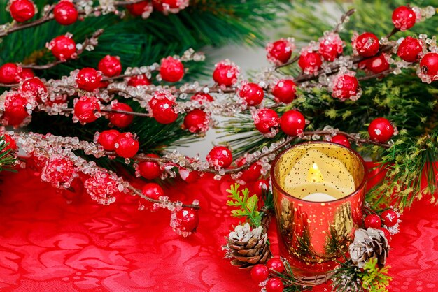 Une baie rouge et une bougie allumée décorent ce fond de Noël