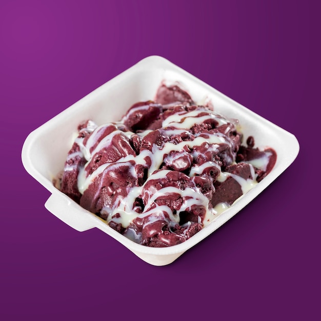 Baies d'açai congelées avec du lait concentré sur une boîte à lunch en polystyrène isolé sur fond violet