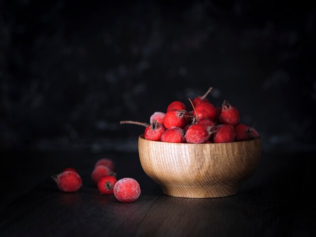 Baies d'aubépine rouge congelées sur fond sombre