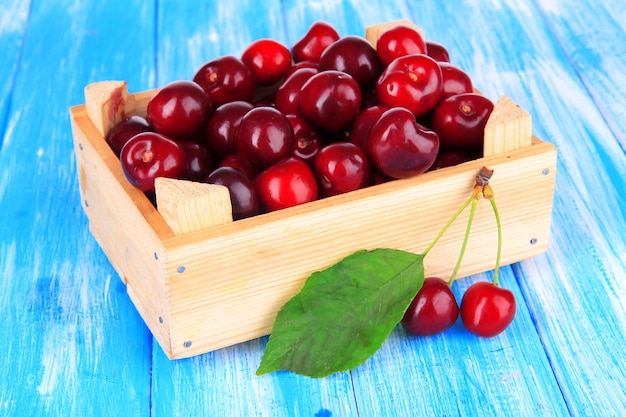 Baies de cerise dans une boîte en bois sur une table en bois