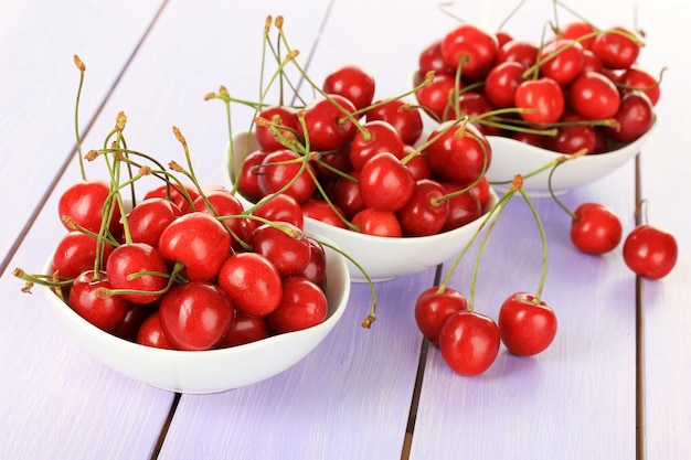 Baies de cerise dans un bol sur une table en bois se bouchent