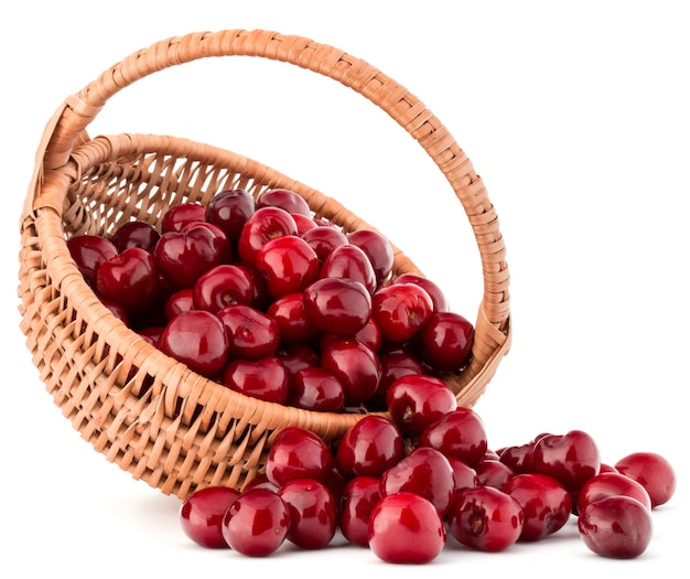 Les baies de cerise dans le panier en osier isolé sur la découpe de fond blanc