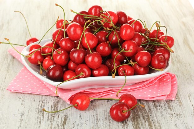 Baies de cerise sur plaque sur table en bois se bouchent