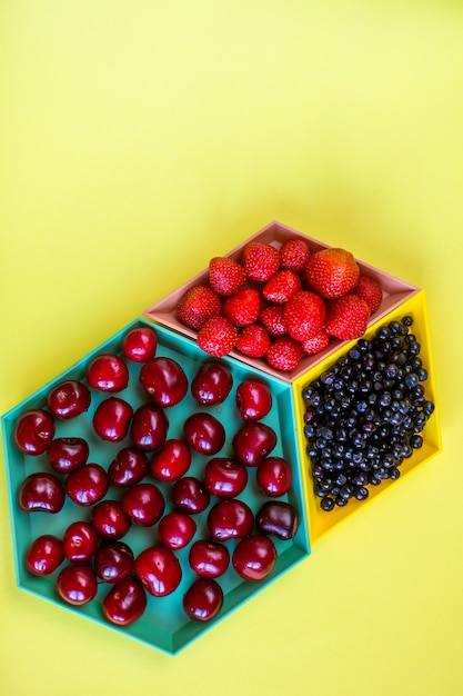 Baies et cerises sur des bols colorés