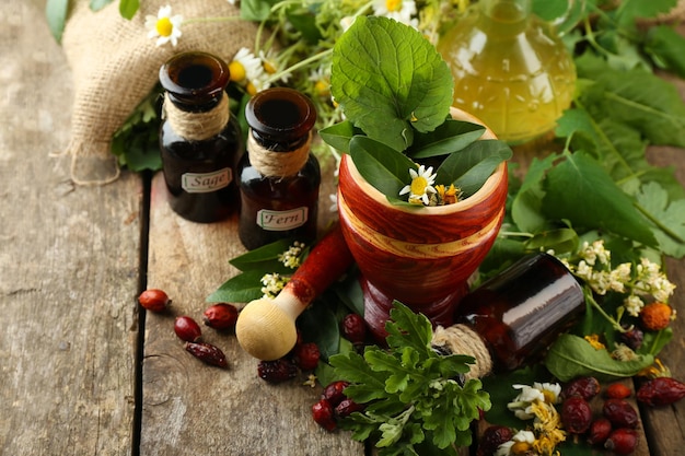 Photo baies et fleurs d'herbes avec du mortier sur le fond de table en bois