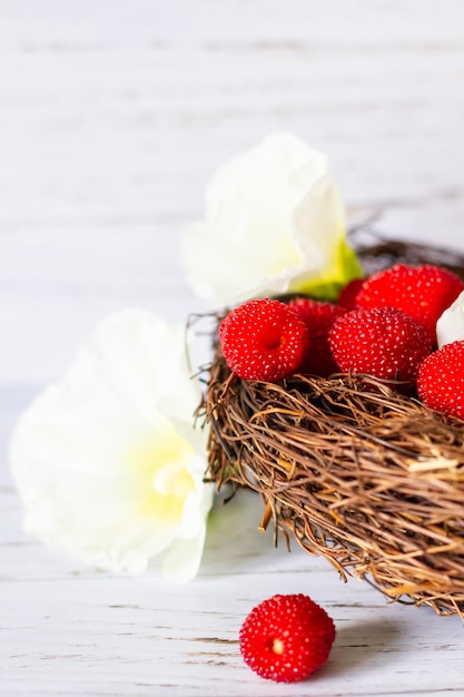 Baies fraîches de framboises tibétaines dans un panier sur un fond en bois