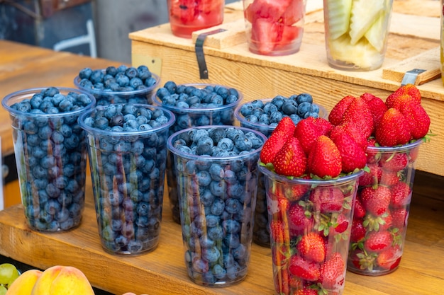 Baies de fraises et de bleuets sur un marché en plein air. Fruits mûrs frais