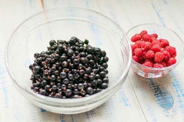 Baies de framboises et de cassis Baies fraîches d'été dans des assiettes