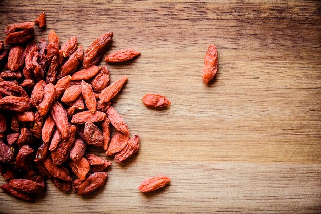 Baies de Goji sur une planche à découper en bois. Vue de dessus