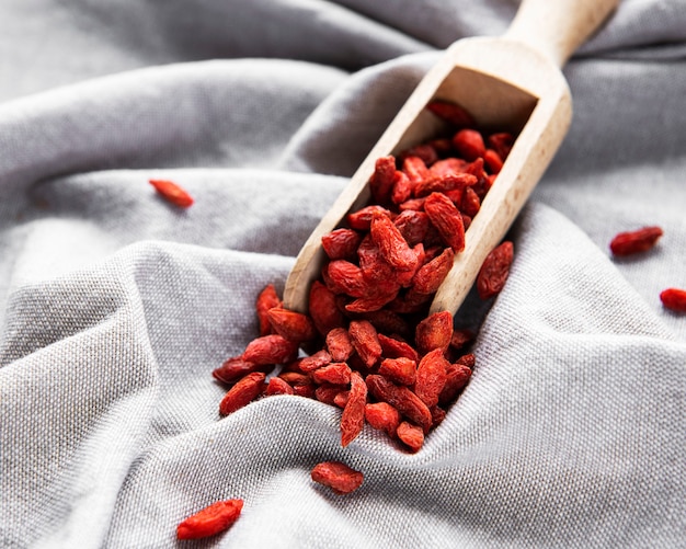 Baies de goji rouges sèches pour une alimentation saine sur fond de tissu