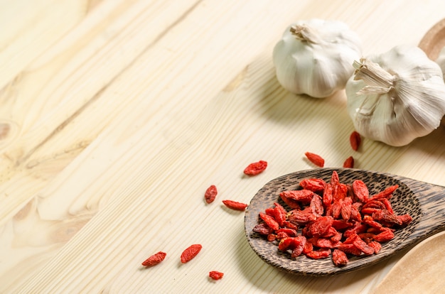 Baies de goji séchées sur une cuillère en bois