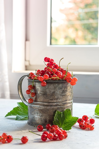 Baies de groseilles rouges mûres fraîches dans une tasse en métal