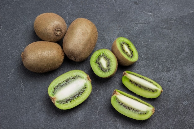 Baies de kiwi hachées et kiwis entiers. Mise à plat