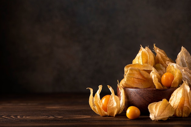 Baies de physalis orange mûres sur une planche de bois, gros plan