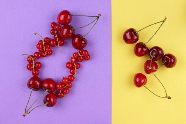 Baies rouges sur fond jaune rose Gros plan de baies sucrées Concept d'aliments sains