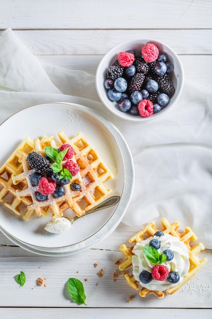 Baies savoureuses avec gaufres et crème fouettée