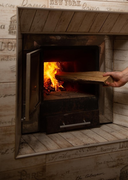 Bain au feu de bois L'homme du préposé au bain tient du bois de chauffage dans ses mains Casser le bain