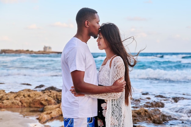 Baiser d'un jeune couple aimant fond de ciel de mer