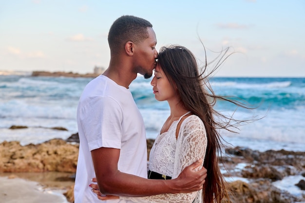 Baiser d'un jeune couple aimant fond de ciel de mer