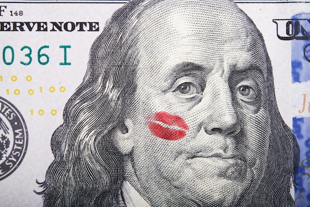 baiser sur portrait de Benjamin Franklin sur un billet de cent dollars.