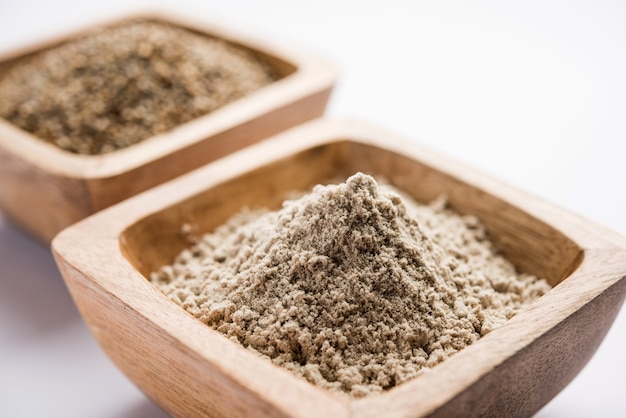 Bajra, millet perlé ou grains de sorgho avec sa farine ou sa poudre dans un bol, mise au point sélective