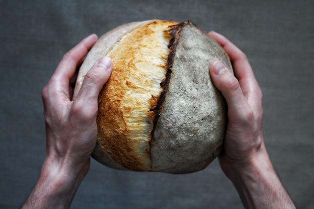 Baker man holding pain au levain blanc pain fait maison photographie alimentaire