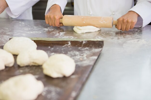 Baker pétrir la pâte avec le rouleau à pâtisserie