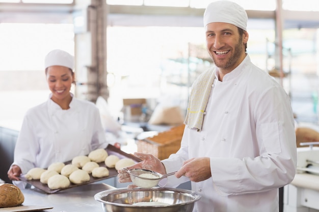 Baker tamisant la farine dans un bol