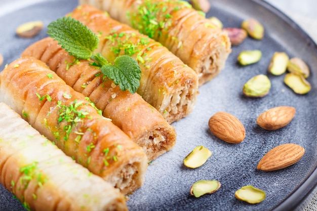 Baklava, bonbons arabes traditionnels en plaque de céramique grise sur un fond de béton gris.