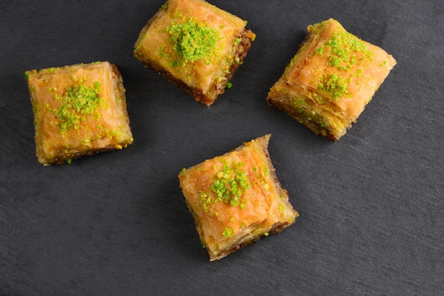 Baklava à la pistache sur une plaque noire. Dessert.