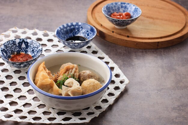 Bakso Arema, Spécialités alimentaires aux boulettes de viande de Malang East Java Indonésie. Gros plan, sur planche de bois et table rustique. Servi avec sauce au soja, sauce et pâte de piment