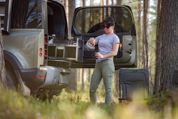 Balade dans la nature en voiture vacances en famille le week-end. La voyageuse apprécie l'heure du café.